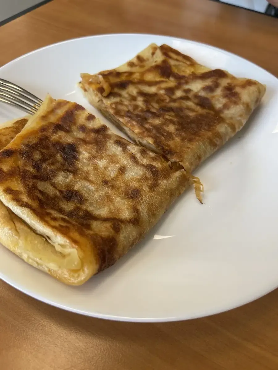 Galette roulée sortie de plaque, dorée, servie dans une assiette.