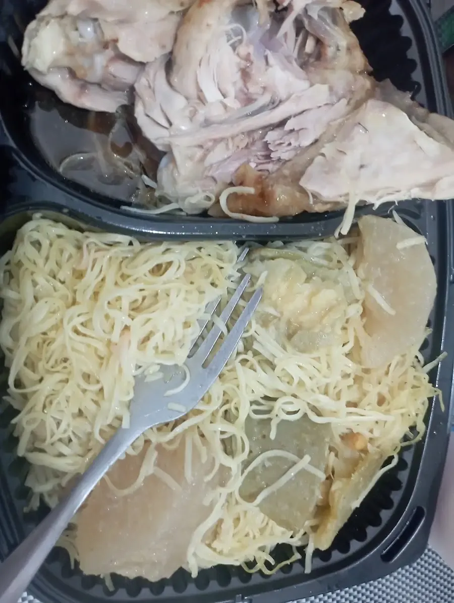 Barquette à emporter : morceaux de poulet et vermicelles blancs.