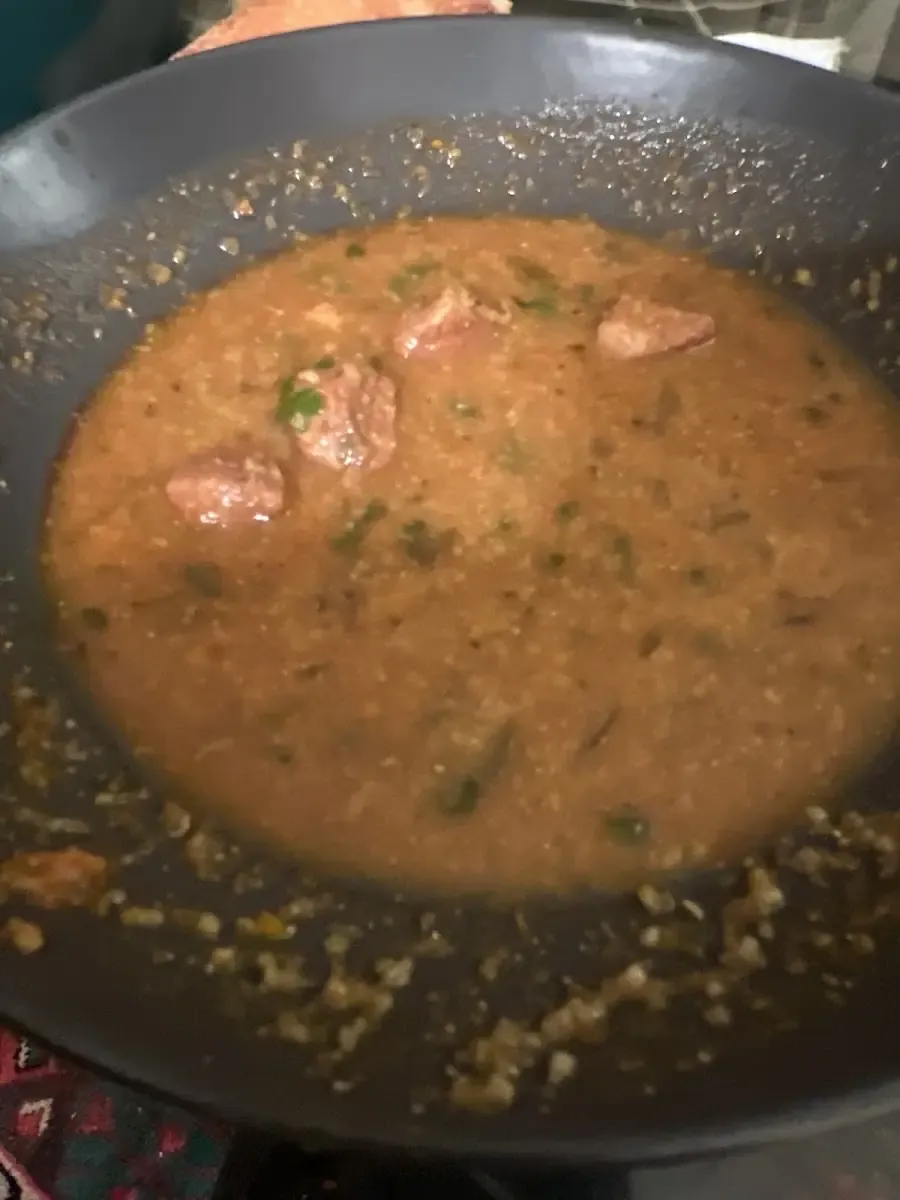 Grande poêle de sauce rouge mijotée avec des merguez.