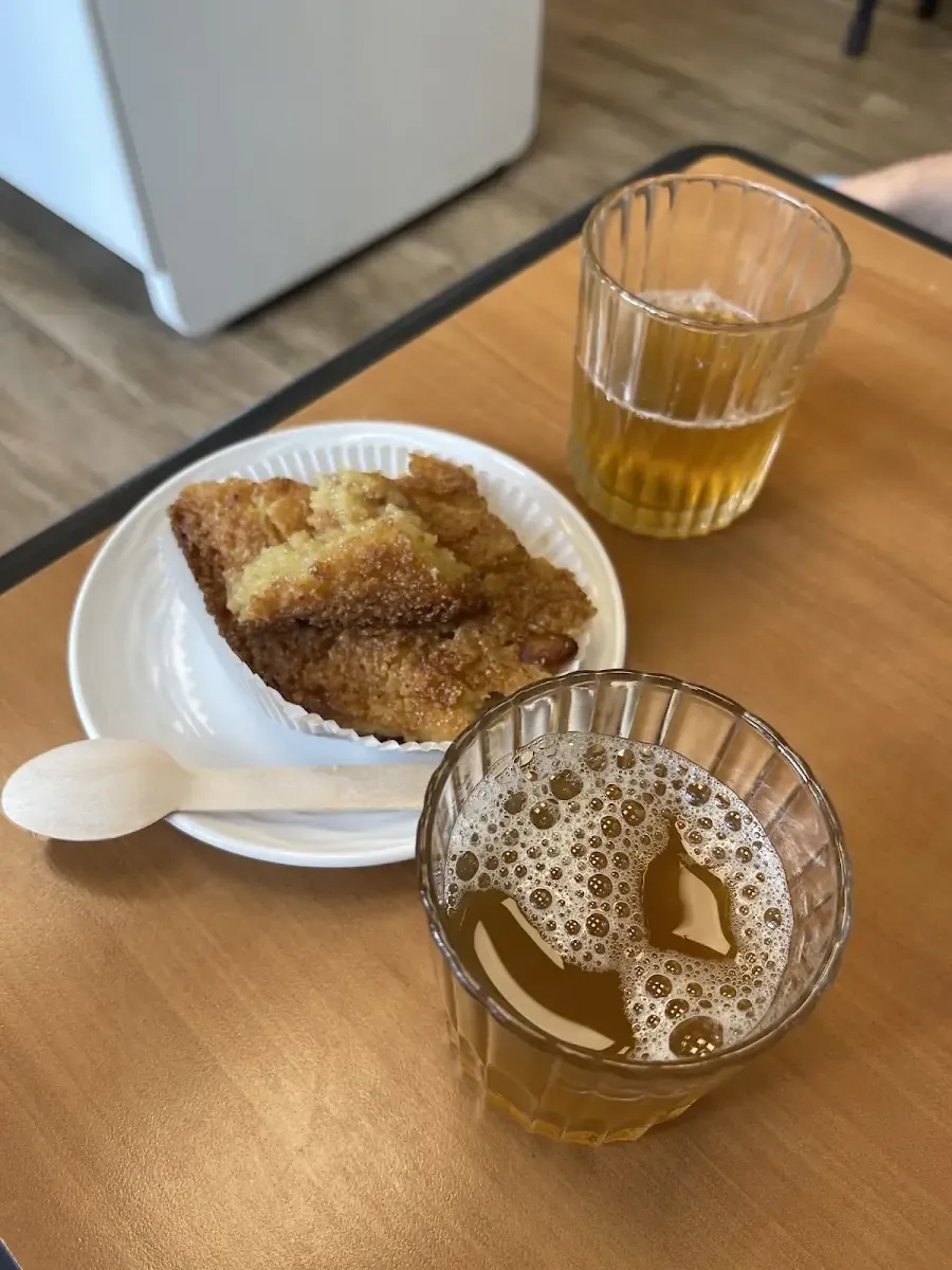 Part de gâteau et deux verres de thé posés sur une table en bois.